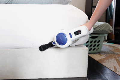 Vacuuming a mattress.